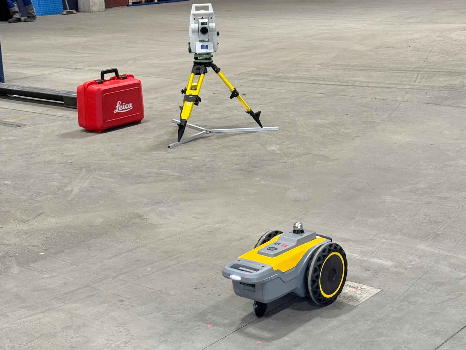 HP SitePrint und Leica Tachymeter vor Regalen in einer Halle